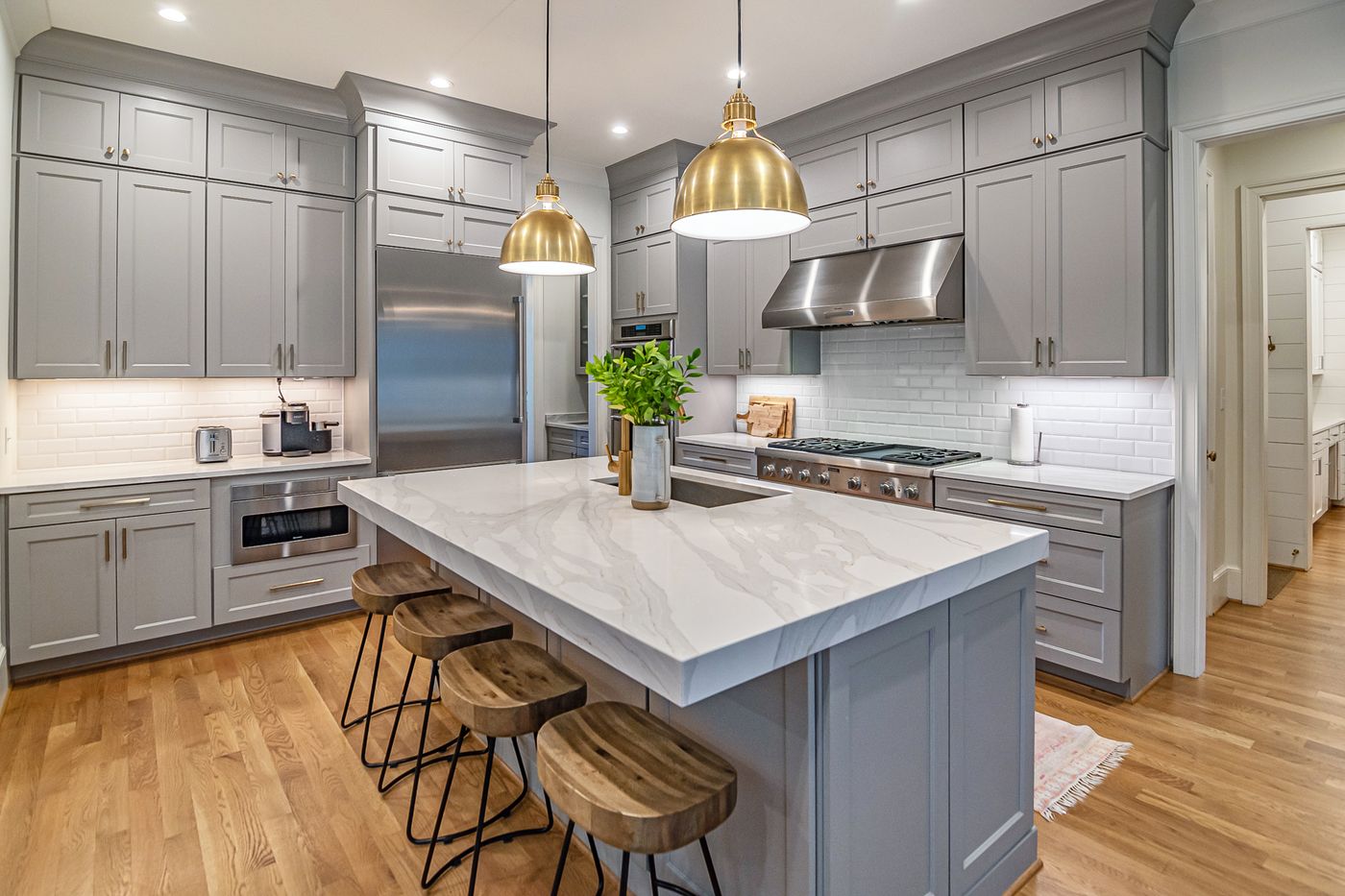 Kitchen renovation with marble island and brass pendant lights